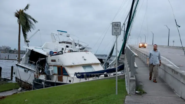 Boats are pushed up on a causeway after Hurricane Ian passed through the area on 29 September 2022