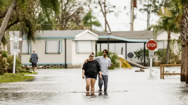 People walking through floodwaters