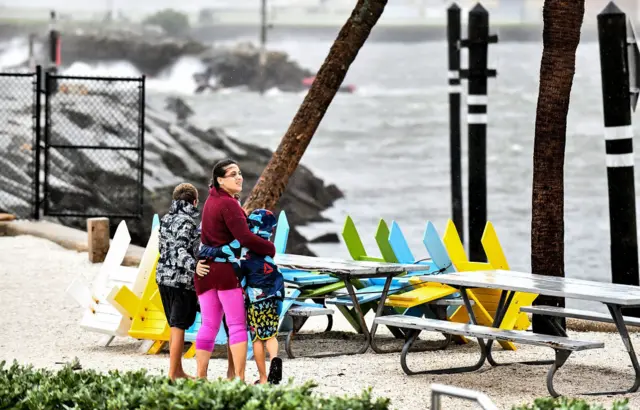 Local residents walk in the middle of rain and heavy wind at the St Pete pier as the Hurricane Ian hits the west coast on 28 September 2022 in St Petersburg, Florida