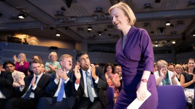 Rishi Suna claps as Liz Truss takes to the stage at the Queen Elizabeth II Centre e on the day it is announced that she is the new Conservative party leader, and will become the next Prime Minister