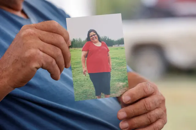 Daryl Burns holds up a photo of his sister Gloria Burns, who was among the victims of the fatal Saskatchewan stabbings.