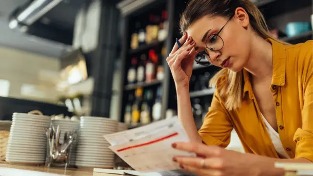 A woman looks at a bill