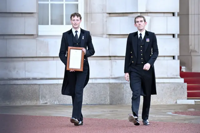 The official Royal announcement of the death of Queen Elizabeth II is carried to be placed on the gates of Buckingham Palace on September