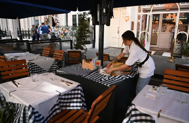 Waitress clearing a table in London