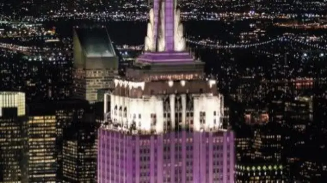 The top of the Empire State Building shining in purple