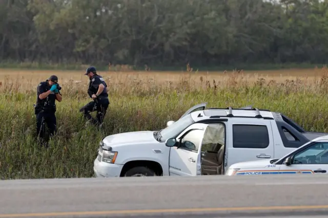 Photo of police next to suspect's vehicle following his arrest.