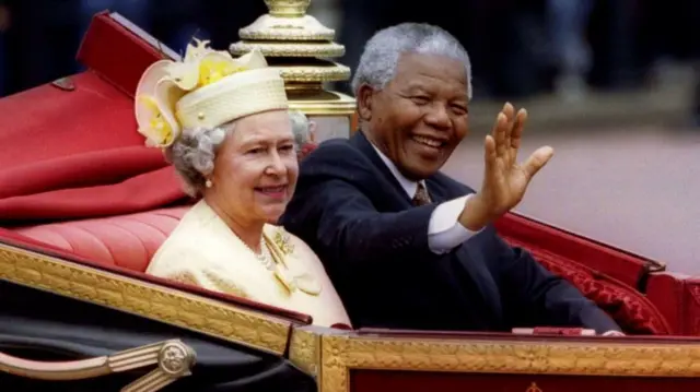 South African President Nelson Mandela is accompanied by Britain's Queen Elizabeth II in a carriage ride to a Buckingham Palace lunch during his state visit, in London, Britain July 9, 1996