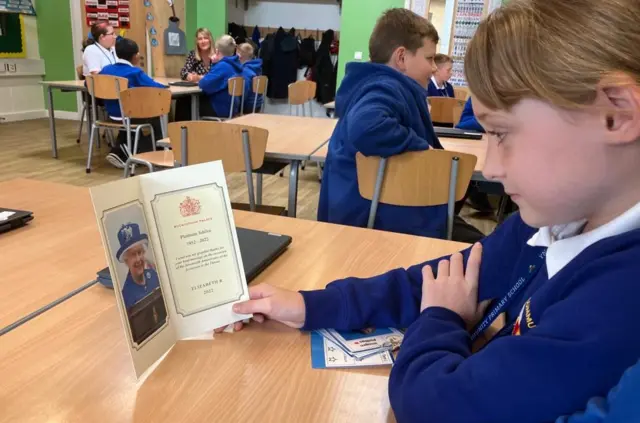 Imogen looks at the book of remembrance she has made for the Queen