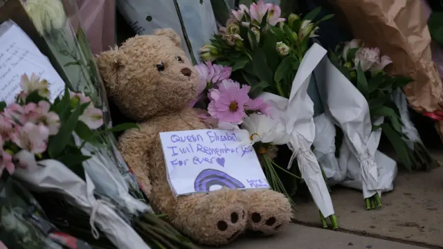 A teddy bear with a note saying 'Queen Elizabeth, I will remember you forever'