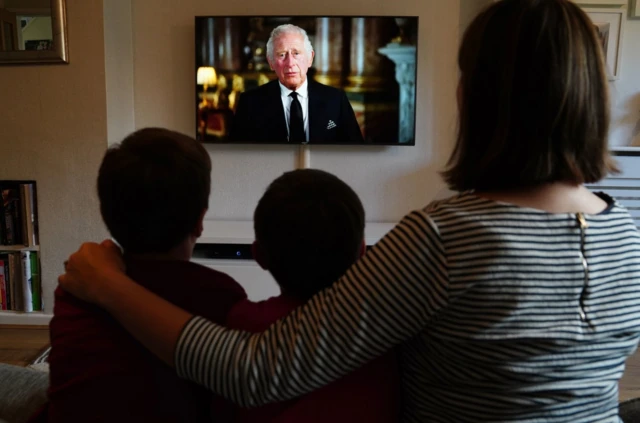 Ben, Isaac and Krystyna Rickett watching a broadcast