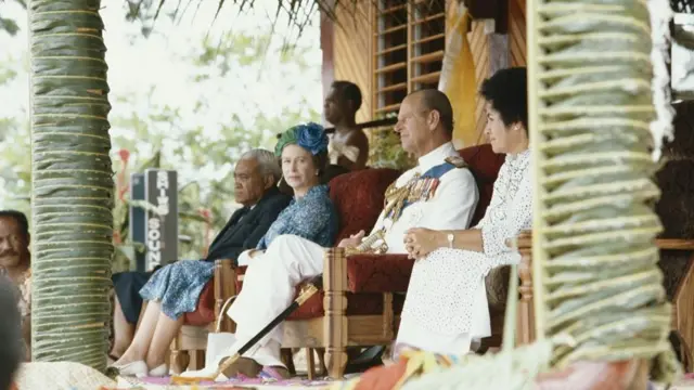 Ratu Sir Kamisese Mara (1920-2004), Queen Elizabeth II, wearing a blue dress, and a blue and green hat, Prince Philip and president of the Fiji Labour Party, Jokapeci Koroi, during a visit to the island of Bau, near Suva, Fiji, 30 October 1982. The Royal couple were on a Royal Tour of Australia and the South Pacific.