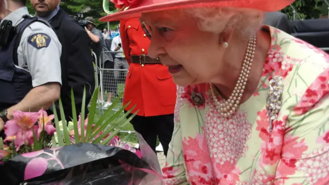 the Queen accepts flowers from the little girl