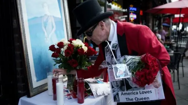 Man lights a candle to honour the Queen