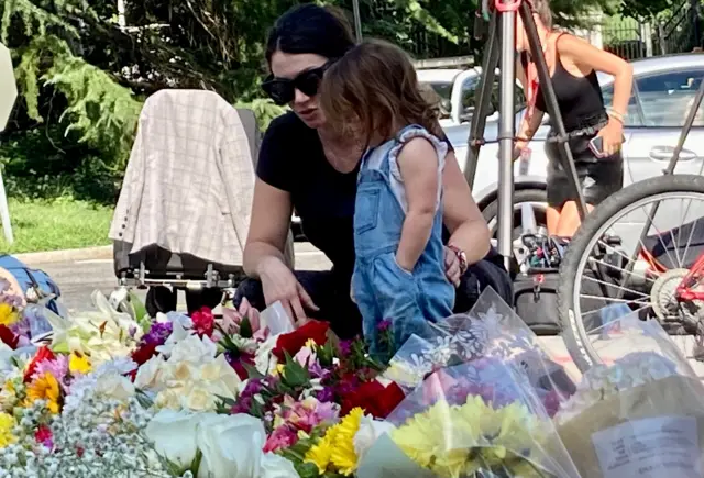 A woman and young child look at lower tributes left outside the British embassy in Washington DC