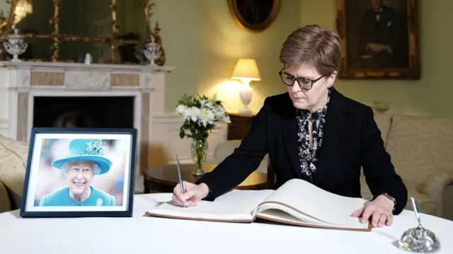 Nicola Stureon writing in book of condolence for the Queen