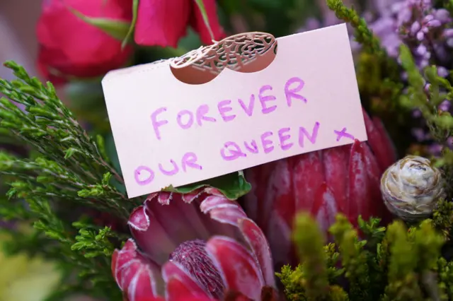 A message left on flowers laid outside Buckingham Palace