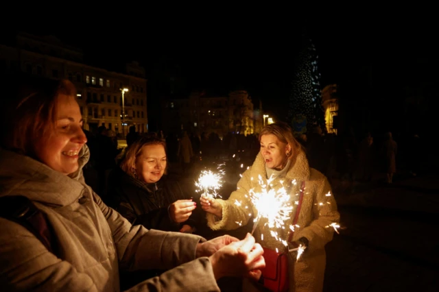Women hold sparklers