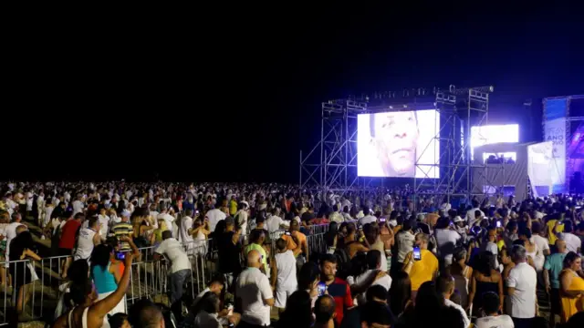 People watch a drone light show in honour of the late Brazilian soccer legend Pele during a New Year's Eve party in Santos,