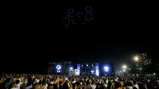 People watch a drone light show in honour of the late Brazilian soccer legend Pele during a New Year's Eve party in Santos,