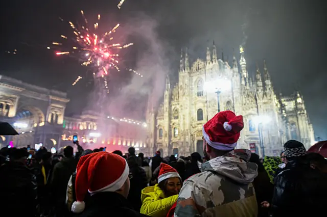 Revellers wear Santa hats beneath Milan's cathedral