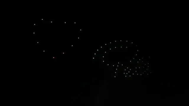 People watch a drone light show in honour of the late Brazilian soccer legend Pele during a New Year's Eve party in Santos,