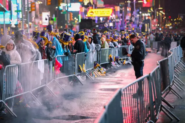 A police officer stands near people gathered in Times Square