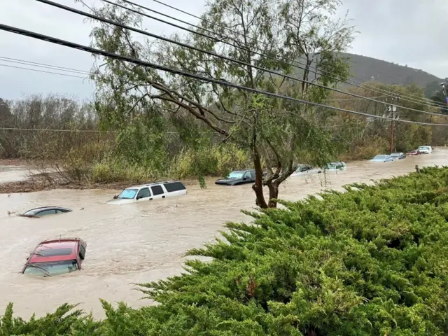 Cars are seen submerged in flood waters in Morro Bay, California