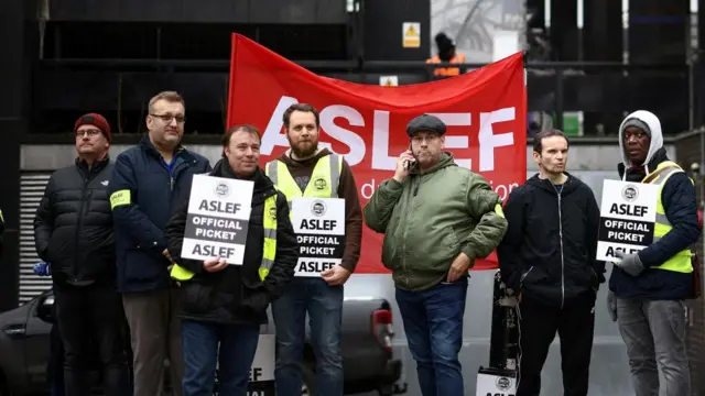 Rail workers that are members of the ASLEF union stand at a picket line outside Euston station while on strike, in Londo