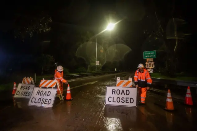 Road workers close the access to the 101 Freeway at Olive Mill Road, Montecito