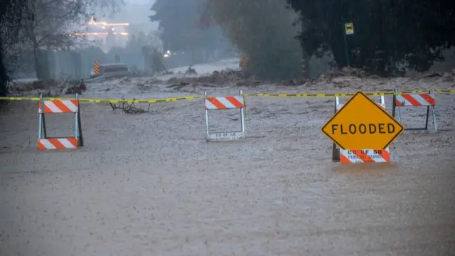 A road in Montecito is flooded out, a result of San Ysidro creek overflowing due to heavy rainfall in the area