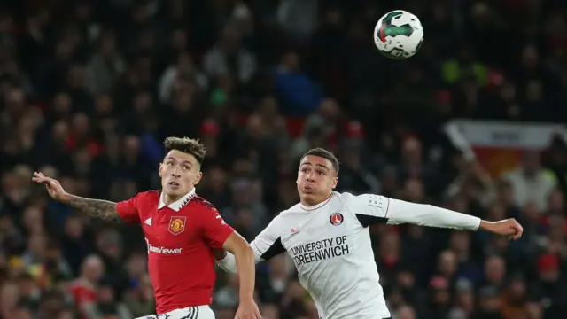 Lisandro Martinez (L) of Manchester United in action with Miles Leaburn (R) of Charlton Athletic