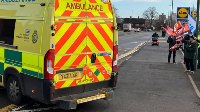 An ambulance leaving the picket line to attend a category one emergency