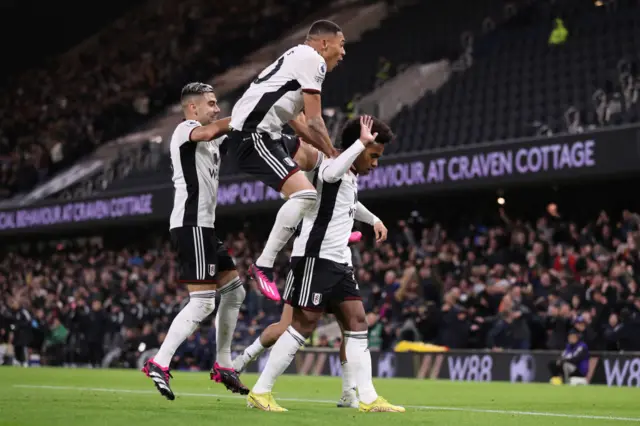 Willian doesn't celebrate after scoring against Chelsea while teammates jump on him.