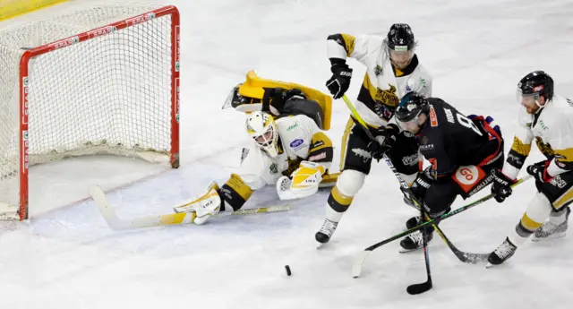 Lewis Hook of Belfast in action against Nottingham Panthers Mike Caruso and netminder Alex Dubeau