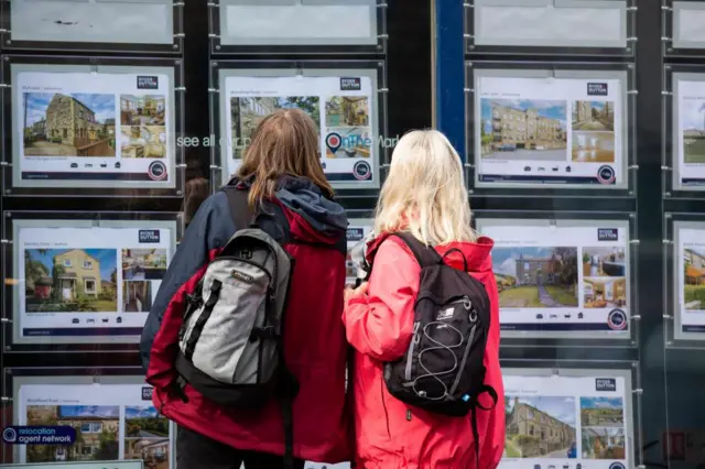 People look at an estate agent's window