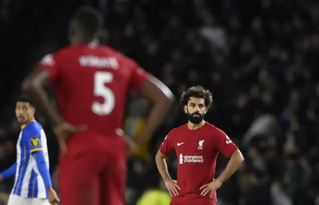 Liverpool players stand shellshocked after conceding a third goal to Brighton.