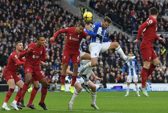 Brighton's Alexis Mac Allister rises highest to meet a cross in the penalty area.