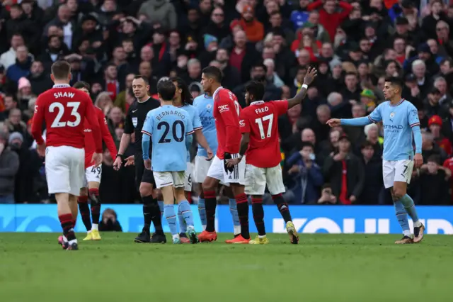 Players from both Man City and Man Utd remonstrate with the referee.