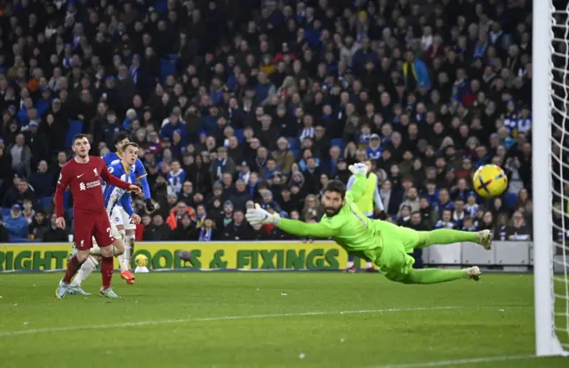 Solly March shoots past Alisson to double Brighton's lead.