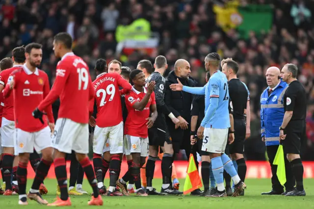 Man City boss Pep Guardiola speaks to the officials after defeat in the Manchester Derby.