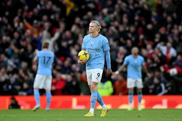 Erling Haaland of Man City carries the ball back to the half way line.