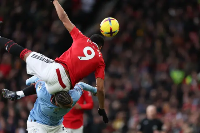 Man Utd's Anthony Martial challenges Man City's Nathan Ake in an aerial duel.