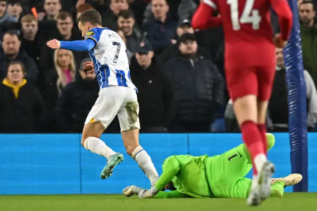 Brighton forward Solly March is challenged by Liverpool keeper Alisson.