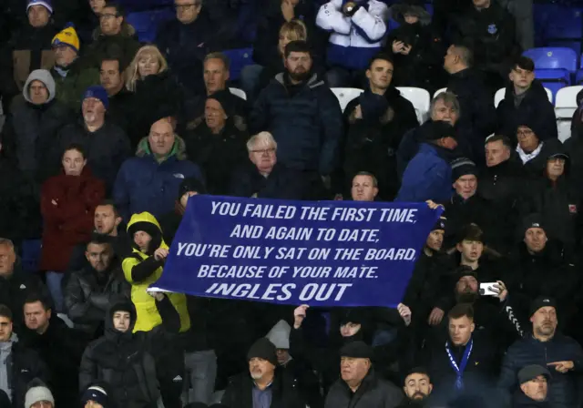 Everton fans hold up a protest banner against the club owners after their latest defeat.