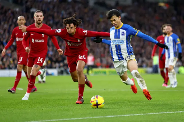 Brighton's Kaoru Mitoma sprints past the Liverpool defence.