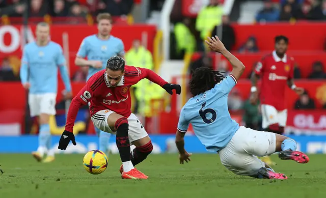 Man Utd's Antony attempts to dribble past the Man City defence.