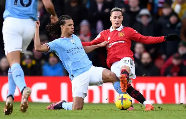 Man City defender Nathan Ake fouls Man Utd forward Antony.