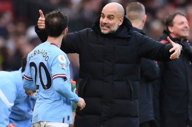 Man City manager Pep Guardiola gives instructions to Bernardo Silva.