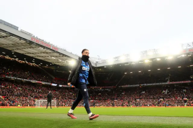 Man City forward Jack Grealish walks down the touchline.