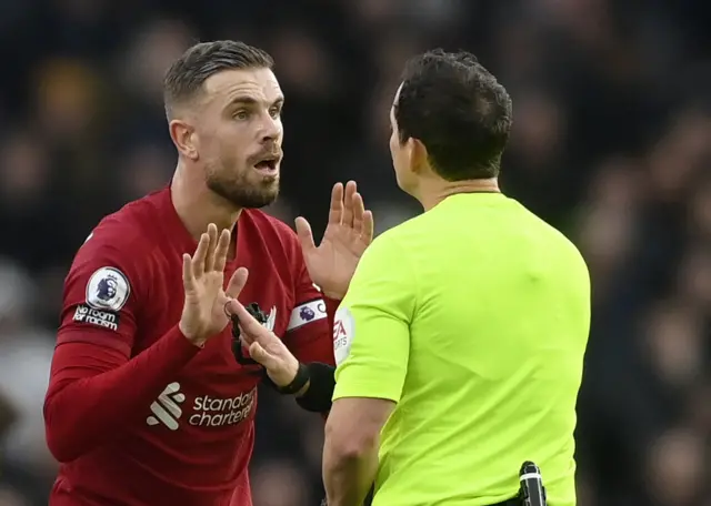 Liverpool captain Jordan Henderson speaks to the match referee.